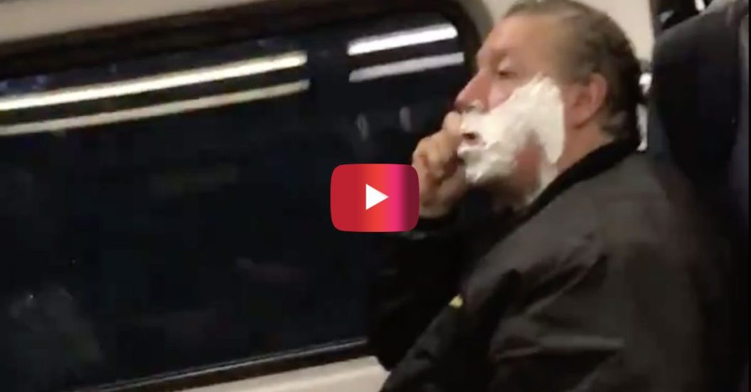Guy shaving on train