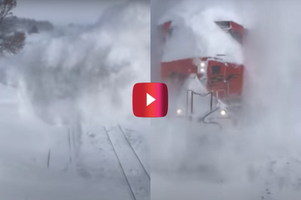 train blasts through snow drift