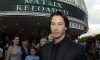keanu reeves standing outside a matrix reloaded marquee