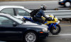 A motorcyclist rides between cars on Highway 101 in Corte Madera, California