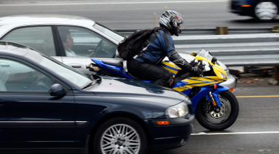 A motorcyclist rides between cars on Highway 101 in Corte Madera, California