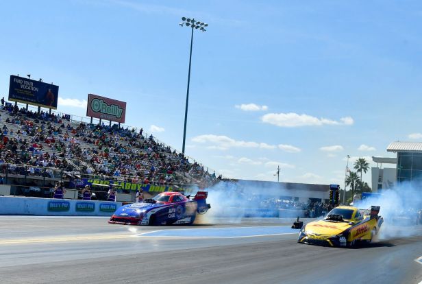 Funny Car drivers J.R. Todd (right) and Robert Hight (left) both smoke their tires off the starting during the final round of eliminations on March 14, 2021, at the season opening AMALIE Motor Oil 52nd annual NHRA Gatornationals at Gainesville Raceway in Gainesville, Florida