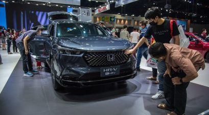 Visitors are seen admiring a "Honda HR-V E:Hev" car displayed at the 38th Thailand International Motor Expo 2021