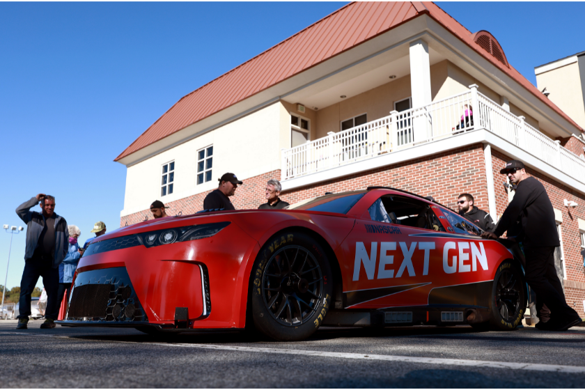 Crew members wait to push the NASCAR Next Gen test car back to its hauler after a session at Bowman Gray Stadium on October 26, 2021 in Winston Salem, North Carolina