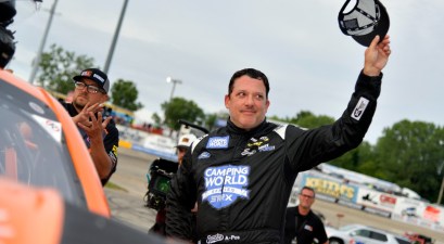 Tony Stewart waves to fans before climbing into his car during the Camping World Superstar Racing Experience event